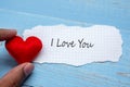 I LOVE YOU word on paper note with red heart shape decoration on blue wooden table background. Wedding, Romantic and Happy Royalty Free Stock Photo